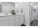 Bathroom featuring double sinks, white cabinets, and a shower with a glass door at 315 Sandridgebury Dr. # 70, Little River, SC 29566