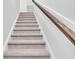 Carpeted staircase featuring a wooden handrail and white trim at 319 Sandridgebury Dr. # 71, Little River, SC 29566