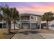 Two-story home with lush landscaping, including mature palms, two car garage, and a classic beachy style at 323 45Th Ave. N, North Myrtle Beach, SC 29582