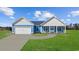 Charming single-story home with blue siding, white trim, a two-car garage, and a welcoming front porch at 3372 Gurley Rd., Loris, SC 29569