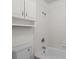 Tiled shower and tub with white tiled walls and matching built in storage cabinet at 4350 Goude St., Murrells Inlet, SC 29576