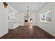 Spacious dining area with wood floors, chandelier, and a view of the white kitchen with a bar at 4350 Goude St., Murrells Inlet, SC 29576