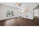 Open-concept living room featuring hardwood floors, staircase, and large windows at 4350 Goude St., Murrells Inlet, SC 29576