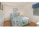 Cozy bedroom with a nautical themed comforter, side table with lamp, and wood floors at 4505 South Ocean Blvd. # 8-D, North Myrtle Beach, SC 29582