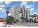 Multi-story condo with balconies, green roof accents, and tropical palm trees at 4505 South Ocean Blvd. # 8-D, North Myrtle Beach, SC 29582