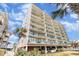 Low angle shot of the condo complex exterior featuring multiple balconies and tropical landscaping at 4505 South Ocean Blvd. # 8-D, North Myrtle Beach, SC 29582