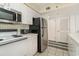 Functional kitchen equipped with stainless steel microwave and refrigerator, alongside white cabinetry for a neat look at 4505 South Ocean Blvd. # 8-D, North Myrtle Beach, SC 29582