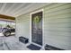 Entrance to the home with green siding, a black door adorned with a wreath, and potted flowers at 5137 Highway 17 Business # 3A, Murrells Inlet, SC 29576