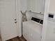 Well-lit laundry room featuring white washer and dryer, ample cabinet space, and a convenient ironing board at 517 Brooksher Dr., Myrtle Beach, SC 29588