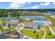 Aerial view of community clubhouse, pools, lake, and surrounding greenery at 5572 Redleaf Rose Dr., Myrtle Beach, SC 29579