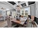 Stylish dining room with modern chandelier, coffered ceiling, and large windows providing ample natural light at 5572 Redleaf Rose Dr., Myrtle Beach, SC 29579