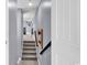 Hallway with staircase leading to a well-lit space and tasteful artwork on the walls at 5572 Redleaf Rose Dr., Myrtle Beach, SC 29579