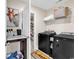 Well-lit laundry room featuring a modern washer and dryer, counter space and unique giraffe wall art at 5572 Redleaf Rose Dr., Myrtle Beach, SC 29579