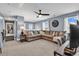 Spacious carpeted living room with large sectional sofa, ceiling fan, and ample natural light at 5572 Redleaf Rose Dr., Myrtle Beach, SC 29579