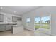 Modern kitchen featuring grey cabinets, granite countertops, island, and backyard pond view at 620 Mccorkle Place, Conway, SC 29526