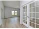 Living room showcasing wood floors and ample natural light with adjacent office or study with french doors at 620 Mccorkle Place, Conway, SC 29526