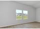 Bright, empty room with light wood flooring and large windows providing views of a pond at 620 Mccorkle Place, Conway, SC 29526