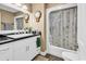 Well-lit bathroom features a vanity with a black countertop and tub with shower at 638 S Waccamaw Dr., Murrells Inlet, SC 29576