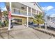 Lovely elevated beach house with an American flag and an open space under the house for parking at 638 S Waccamaw Dr., Murrells Inlet, SC 29576