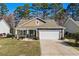 Charming single story home with a stone and shake exterior, a well-manicured lawn, and an attached two car garage at 725 Old Castle Loop, Myrtle Beach, SC 29579