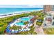 Aerial view showcases a lagoon-style pool and beach access next to a modern resort at 7322 Sarteano Dr., Myrtle Beach, SC 29572