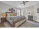 Cozy bedroom with a decorative ceiling fan, wood-look floors, and framed floral artwork above the bed at 7322 Sarteano Dr., Myrtle Beach, SC 29572