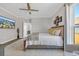 Bedroom with a ceiling fan, warm wood-look floors, and a view of the exterior from the side window at 7322 Sarteano Dr., Myrtle Beach, SC 29572