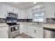 Updated kitchen showcasing white cabinetry, granite counters, stainless steel appliances, and modern fixtures at 7609 Driftwood Dr., Myrtle Beach, SC 29572