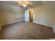 A bedroom with neutral carpet and walls, ceiling fan, and an open doorway at 1000 Weldon Ln., Conway, SC 29526