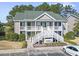 Inviting two-story tan condo featuring white balconies, green roof, and ample parking at 1081 Blue Stem Dr. # 35-B, Pawleys Island, SC 29585