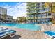 Inviting outdoor pool surrounded by lounge chairs and lush landscaping at this resort at 1105 S Ocean Blvd. # 1004, Myrtle Beach, SC 29577