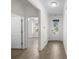 Hallway with wood-look flooring leading to a room with a window and a door to the outside at 1108 Inlet View Dr., North Myrtle Beach, SC 29582