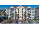 Three story condo building with exterior staircases, ample parking, and landscaped areas at 117 Ella Kinley Circle # 201, Myrtle Beach, SC 29588