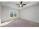 Bright bedroom featuring carpet flooring, ceiling fan, and a large window at 1239 Cypress Shoal Dr., Conway, SC 29526