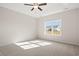 Bright main bedroom featuring a ceiling fan, carpet flooring, and a large window offering natural light at 124 Old Chimney Ln, Conway, SC 29526