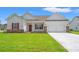 Charming single-story home featuring a well-manicured lawn and a two-car garage at 124 Old Chimney Ln, Conway, SC 29526
