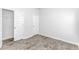 Bedroom with wood-look flooring, neutral paint, and white doors to closet and hallway at 1329 Palm Springs Paloma Dr, Longs, SC 29568