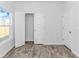 Bedroom with wood-look flooring, one window, neutral paint, and doors to closet and hallway at 1329 Palm Springs Paloma Dr, Longs, SC 29568