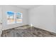 Bright bedroom with gray wood-look floors and natural light from two windows overlooking the street at 1329 Palm Springs Paloma Dr, Longs, SC 29568