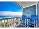 This outdoor balcony sitting area features amazing ocean views and cozy blue chairs at 1417 S Ocean Blvd. # 202, Surfside Beach, SC 29575