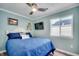 Comfortable bedroom with blue walls, ceiling fan, and natural light from the window at 1417 S Ocean Blvd. # 202, Surfside Beach, SC 29575