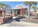 Exterior view of Gracious Pig Smokehouse, with palm trees, seating, and prominent signage at 1424 Glenns Bay Rd. # 1424, Myrtle Beach, SC 29575