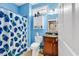 Well-lit, blue bathroom with a shower-tub combo and decorative shower curtain at 1424 Powhaton Dr., Myrtle Beach, SC 29577