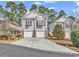 Attractive two-story home with a two-car garage, complemented by a concrete driveway and mature trees at 1424 Powhaton Dr., Myrtle Beach, SC 29577