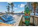 Comfortable lounge chairs on wooden pool deck with palm trees, colorful decoration, beach, and ocean in the background at 158 Seawatch Dr. # 1112, Myrtle Beach, SC 29572