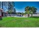 Spacious backyard featuring a pool, mature palm trees, lots of green space, and privacy at 1585 Brookgreen Dr., Myrtle Beach, SC 29577