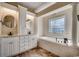 Bright bathroom with double vanities, a soaking tub, tile flooring, and neutral walls at 1585 Brookgreen Dr., Myrtle Beach, SC 29577