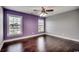 Bedroom with hardwood floors, two windows, and light purple accent wall at 1585 Brookgreen Dr., Myrtle Beach, SC 29577