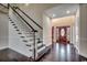 Elegant foyer with hardwood floors, staircase with white railings, and decorative front door at 1585 Brookgreen Dr., Myrtle Beach, SC 29577