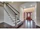 Bright foyer features hardwood floors, a staircase with white railing, and a decorative wood front door at 1585 Brookgreen Dr., Myrtle Beach, SC 29577